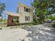 Charming two-story home with a gravel driveway, brick chimney and mature trees at 2418 W 1St St, Sanford, FL 32771