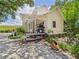 Back view of a two-story home with a porch, garden, and a gravel driveway at 2418 W 1St St, Sanford, FL 32771