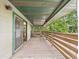 Spacious wooden porch with a picnic table and a green ceiling overlooking lush greenery at 2418 W 1St St, Sanford, FL 32771