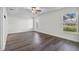 Spacious bedroom features wood-look floors, ceiling fan, tray ceiling, and lots of natural light from windows at 2505 Brownwood Dr, Mulberry, FL 33860
