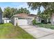 Side view of a well-maintained single-story home with attached garage and green lawn at 2505 Brownwood Dr, Mulberry, FL 33860