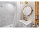 Modern bathroom with marble-tiled shower, sleek vanity, gold hardware, and stylish round mirror at 4125 Sunny View Dr, Lakeland, FL 33813