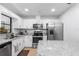Well-lit kitchen with white cabinets, stainless steel appliances, and granite countertops at 4125 Sunny View Dr, Lakeland, FL 33813