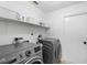 This laundry room has a front-load washer and dryer, as well as storage shelves at 4125 Sunny View Dr, Lakeland, FL 33813