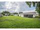 Lush, grassy backyard with a white house in the background and a wood fence at 4921 Sharon Ave, Lakeland, FL 33812