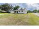 Charming single-story home with white brick exterior, attached garage, and well-maintained front lawn at 4921 Sharon Ave, Lakeland, FL 33812