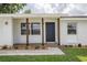 Inviting front entrance with a dark colored front door framed by wood columns and fresh landscaping at 4921 Sharon Ave, Lakeland, FL 33812