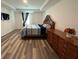 Bedroom with wood-look floors, tray ceiling, and a bed with a decorative headboard at 516 Ingleside Ln, Haines City, FL 33844