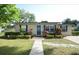 Charming home featuring mature landscaping, a well-manicured lawn, and a welcoming blue front door at 520 Oakland Rd, Auburndale, FL 33823