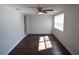 Bright living room featuring dark hardwood floors, neutral wall color, and a ceiling fan at 520 Oakland Rd, Auburndale, FL 33823