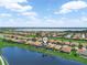 Stunning aerial view of community homes, golf course, and beautiful lake in a tranquil, sunny setting at 5200 Pebble Beach Blvd, Winter Haven, FL 33884