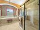 An opulent bathroom features a seamless glass shower, soaking tub, and decorative columns at 5200 Pebble Beach Blvd, Winter Haven, FL 33884