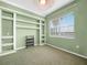 Bright bedroom featuring green walls, carpet flooring, built-in shelving and a large window at 5200 Pebble Beach Blvd, Winter Haven, FL 33884