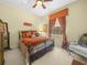 Comfortable bedroom featuring a plush bed, decorative window treatments, and a cozy sitting area at 5200 Pebble Beach Blvd, Winter Haven, FL 33884