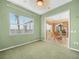 Empty green bedroom featuring carpet flooring, a large window and an open doorway at 5200 Pebble Beach Blvd, Winter Haven, FL 33884