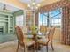 Charming breakfast nook with a glass table, stylish chairs, and a view to the built-in shelves in the next room at 5200 Pebble Beach Blvd, Winter Haven, FL 33884