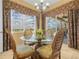Inviting breakfast nook featuring a glass table and elegant chairs with views of the outdoors and pool at 5200 Pebble Beach Blvd, Winter Haven, FL 33884