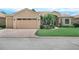 Charming single-story home with a two-car garage, well-manicured lawn, and mature palm trees at 5200 Pebble Beach Blvd, Winter Haven, FL 33884