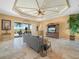Comfortable living room featuring travertine floors, a decorative ceiling, and access to the pool area at 5200 Pebble Beach Blvd, Winter Haven, FL 33884