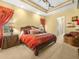Luxurious main bedroom showcasing a decorative tray ceiling and a comfortable sitting area at 5200 Pebble Beach Blvd, Winter Haven, FL 33884
