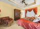 Spacious main bedroom featuring a tray ceiling, a large wardrobe, and a plush bed at 5200 Pebble Beach Blvd, Winter Haven, FL 33884