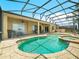 The screened-in pool and spa offer ample seating with a view of manicured landscaping at 5200 Pebble Beach Blvd, Winter Haven, FL 33884