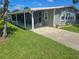 View of the home's side entrance and a covered patio area, enhanced by verdant lawn at 6685 Briarhill Dr Ne, Winter Haven, FL 33881