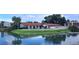 Aerial view showcases the pool, lake, bridge and lovely villas with terracotta roofs at 7201 Country Club Dr # G21, Lake Wales, FL 33898
