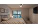 Bedroom with Queen bed, art on the wall, access to a screened in patio and large closet at 7201 Country Club Dr # G21, Lake Wales, FL 33898