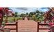 View of community boardwalk over lake, surrounded by tropical plants and landscaping at 7201 Country Club Dr # G21, Lake Wales, FL 33898