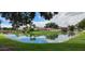 Beautiful community featuring a pond, bridge, lush greenery, and well-maintained buildings with red tile roofs at 7201 Country Club Dr # G21, Lake Wales, FL 33898