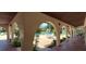 Covered patio view overlooking pool with tables, chairs, and lush tropical landscaping at 7201 Country Club Dr # G21, Lake Wales, FL 33898