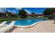 Inviting community pool surrounded by lounge chairs and lush landscaping with lake views at 7201 Country Club Dr # G21, Lake Wales, FL 33898