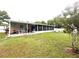 Spacious backyard featuring a screened-in patio and lush landscaping at 7814 Plunkett Ave, Orlando, FL 32810