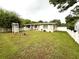 Spacious backyard with a charming white picket fence and well-maintained lawn at 7814 Plunkett Ave, Orlando, FL 32810
