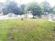 Large front yard with a bird bath, an arbor, a white picket fence and mature trees at 7814 Plunkett Ave, Orlando, FL 32810