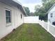 Side yard with a new white picket fence providing privacy at 7814 Plunkett Ave, Orlando, FL 32810
