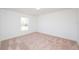 Bright bedroom with carpeted floors and a window overlooking the backyard at 2173 Emma Ln, Lake Wales, FL 33859