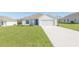 Well-maintained one-story home with a spacious front yard and a long driveway leading to the garage at 2173 Emma Ln, Lake Wales, FL 33859