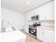 Clean kitchen boasting stainless steel appliances, white cabinets, and plenty of counter space for meal prep at 2173 Emma Ln, Lake Wales, FL 33859