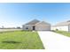 Newly constructed tan house with a two-car garage and green lawn at 322 Brennan Ave, Frostproof, FL 33843