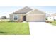 Tan house with a two-car garage and a well-manicured lawn at 322 Brennan Ave, Frostproof, FL 33843