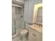 A small bathroom with white fixtures, white tile, and a shower with sliding glass doors at 1019 Grove St # 85, Maitland, FL 32751