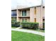 Two-story condo with tan stucco exterior, black metal balcony, and mature shrubbery at 1019 Grove St # 85, Maitland, FL 32751