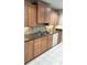 Well-lit kitchen featuring granite countertops, backsplash, stainless steel sink, and shaker style cabinets at 1019 Grove St # 85, Maitland, FL 32751