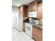 Bright kitchen featuring stainless sink, granite counters, wood cabinets, and white appliances at 1019 Grove St # 85, Maitland, FL 32751