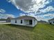 Exterior view of the home showcasing a covered patio and well-maintained backyard lawn space at 227 Bryce Ln, Frostproof, FL 33843