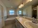 Elegant bathroom featuring double vanity sinks, a soaking tub, and a separate shower at 227 Bryce Ln, Frostproof, FL 33843