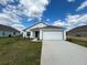 Charming single-story home with a two-car garage, green lawn, and inviting curb appeal at 227 Bryce Ln, Frostproof, FL 33843