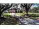 Beautiful single Gathering home with a metal gate, long driveway, and lush green yard at 1004 Country Oaks Ln, Lakeland, FL 33810